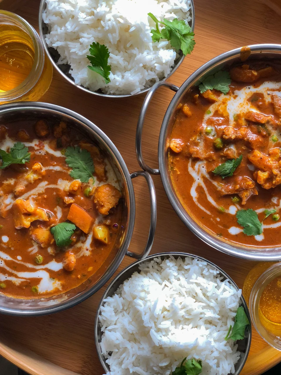Curry dishes served with bowls of white rice