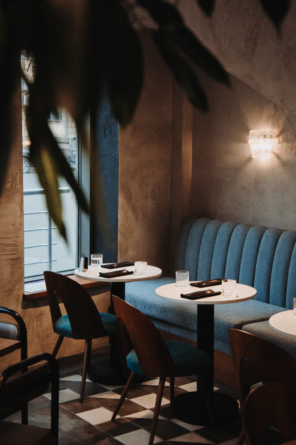 Restaurant seating with blue banquettes and pendant lighting
